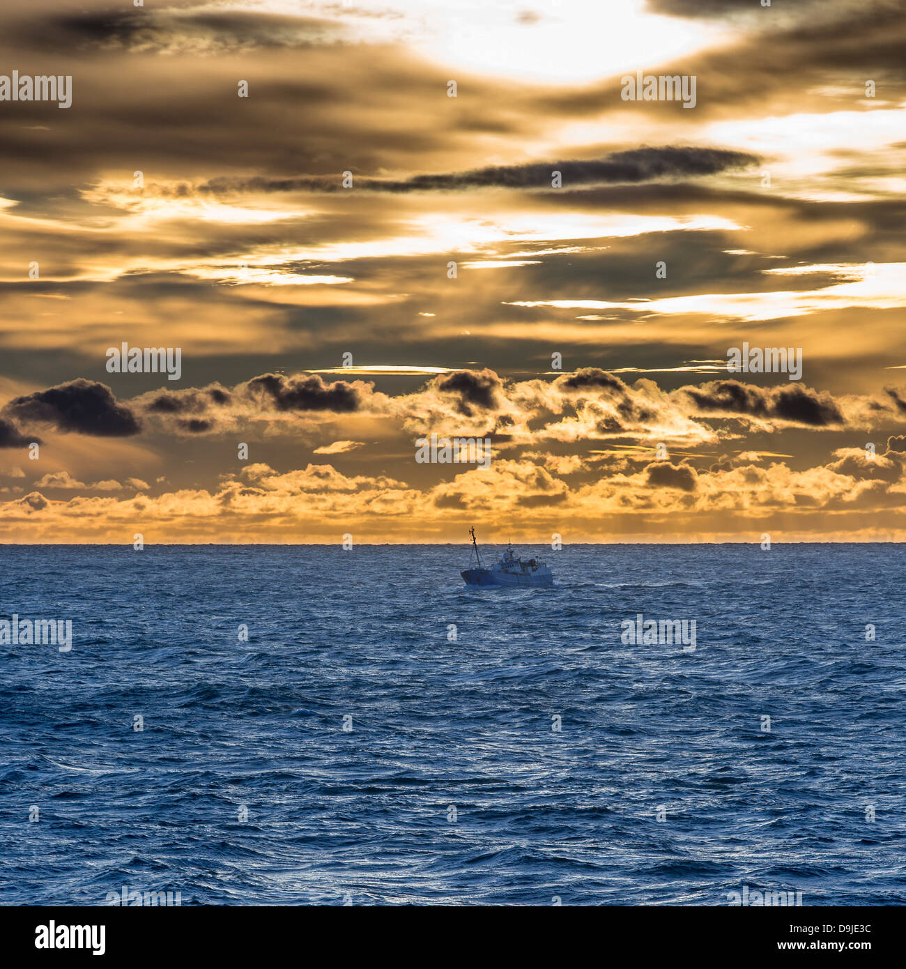 Fischkutter mit Sonnenuntergang und Wolken über dem Atlantischen Ozean, Westmännerinseln, Island Stockfoto