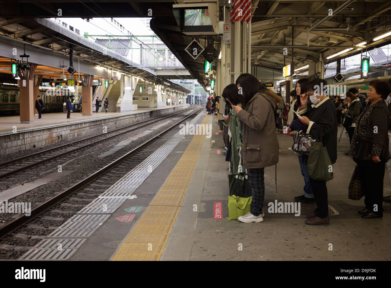 Japanische Passagiere ordentlich und geduldig am Bahnhof JR Sendai-Plattform für ihre lokalen Zug warten Stockfoto