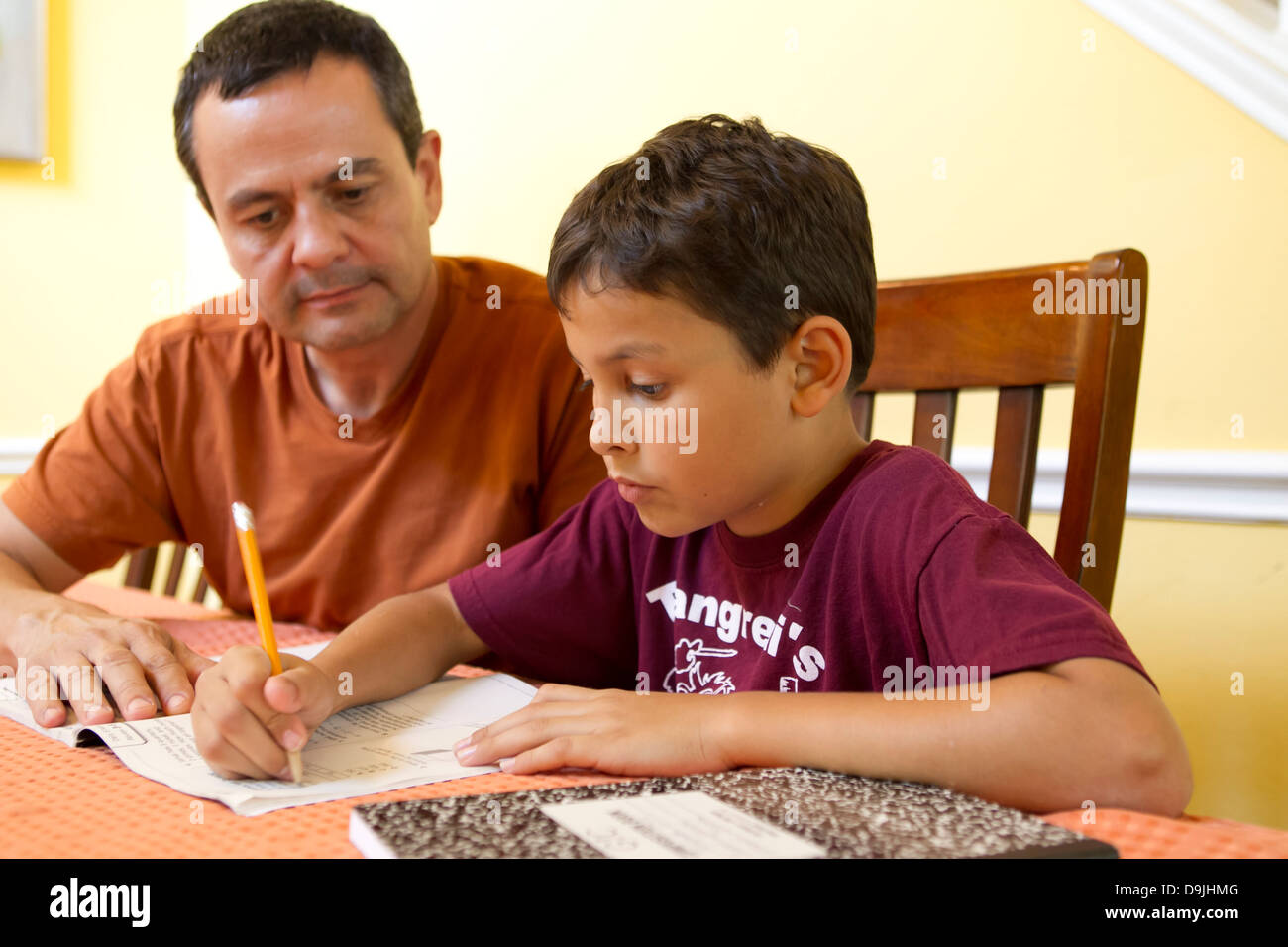 Mexikanisch-amerikanischen Vater (50 Jahre alt) hilft seinen Hispanic 9 Jahre alten Sohn mit Mathe-Hausaufgaben zu Hause. Stockfoto