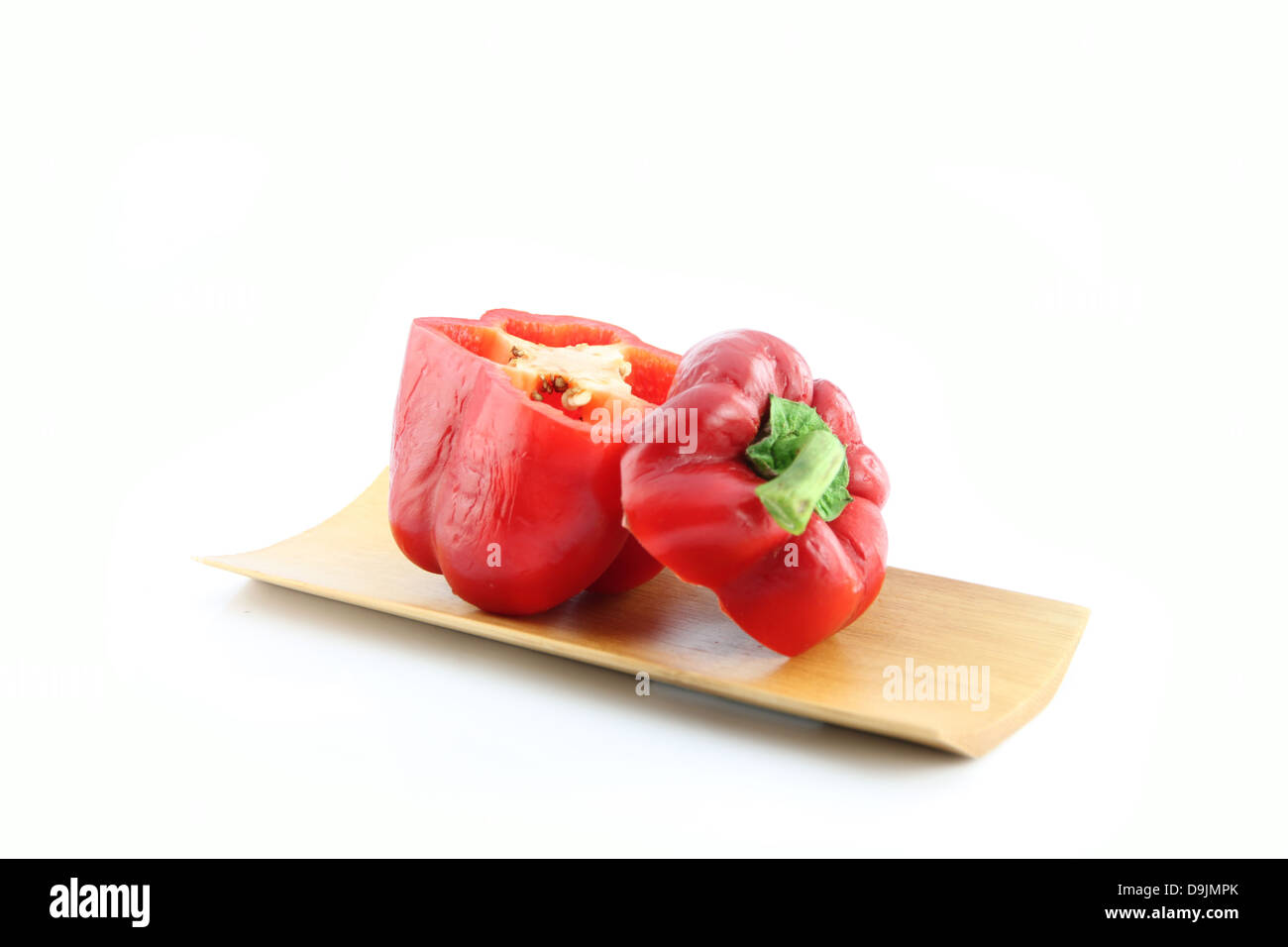 Die roten Paprika Slice in der Bambus-Schale auf weißem Hintergrund. Stockfoto