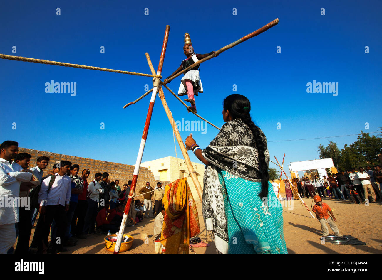 Eine Mädchen führt ein Akrobat in Jaisalmer, Indien. Die Veranstaltung ist Teil der Wüste Festival. Stockfoto