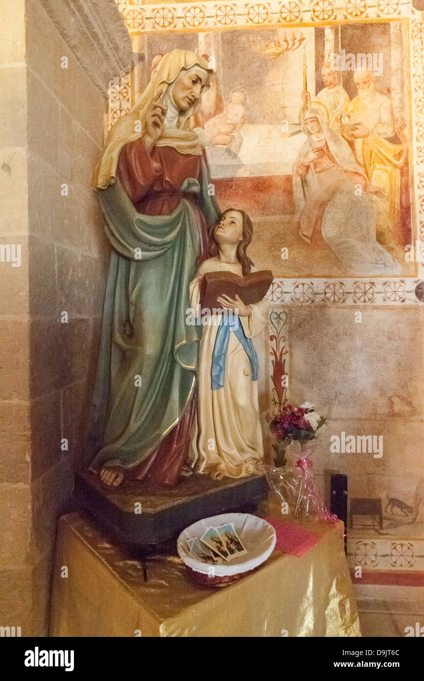 Eine Statue in der Kirche von Sant' Anna, Specchia Gallone, in der Nähe von Lecce, Apulien, Italien. Fresken erzählen die Geschichte auf jeden Haupt Mauer. Stockfoto