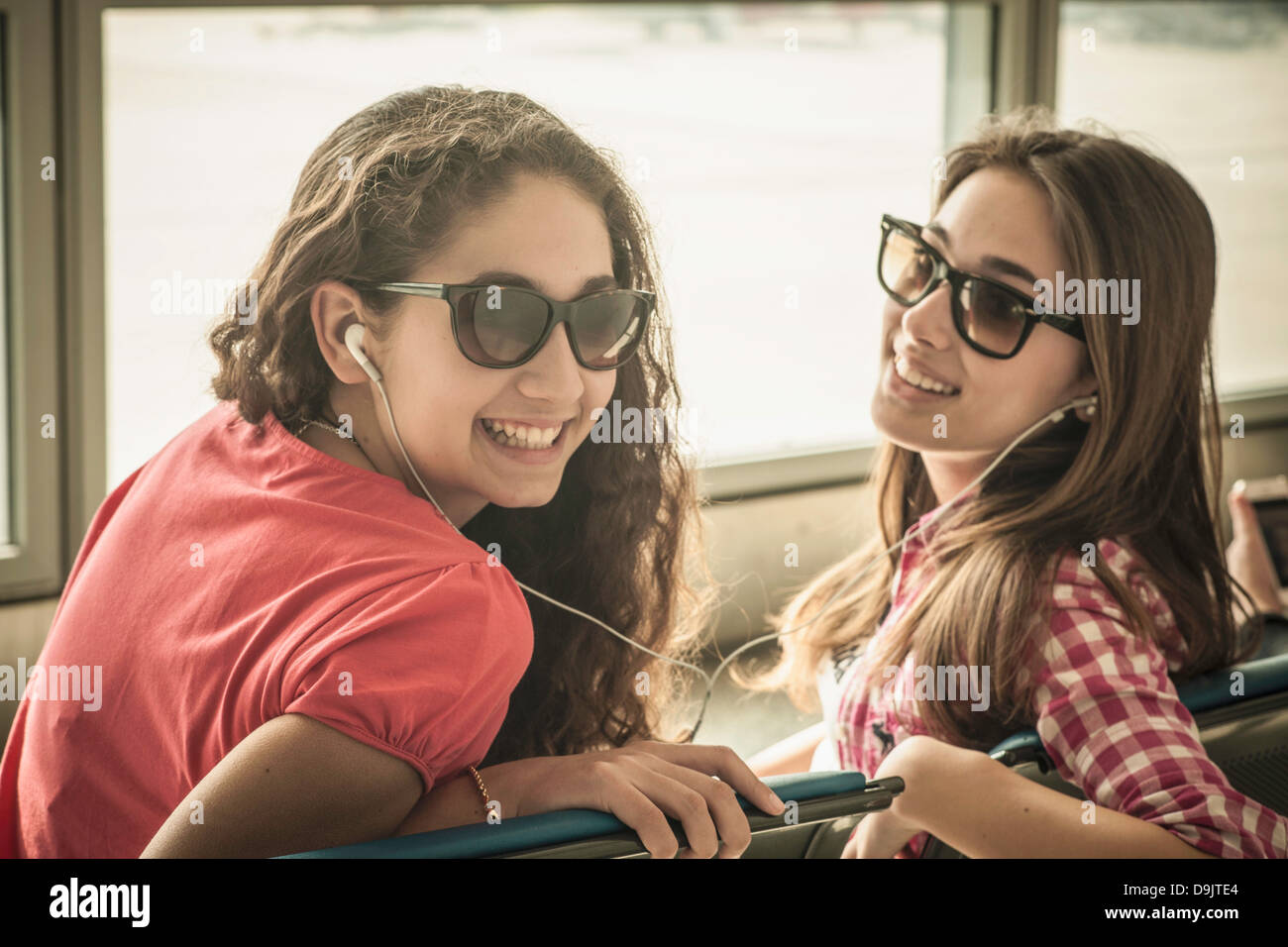 Zwei Mädchen im Teenageralter mit Sonnenbrille, Musik hören Stockfoto