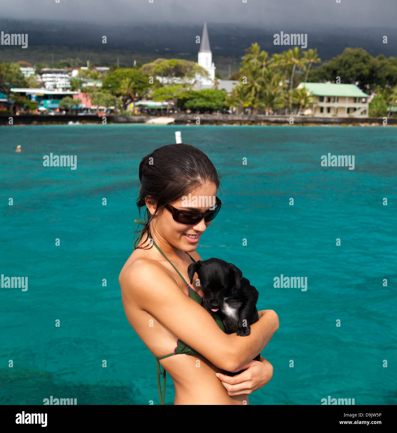 Junge Frau mit ihrem Hund auf dem Pier in Kailua-Kona auf Big Island von Hawaii Stockfoto