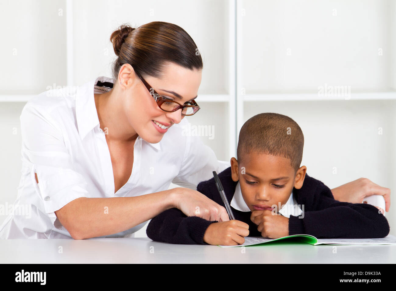 Pflege Volksschullehrer helfen Schüler Stockfoto