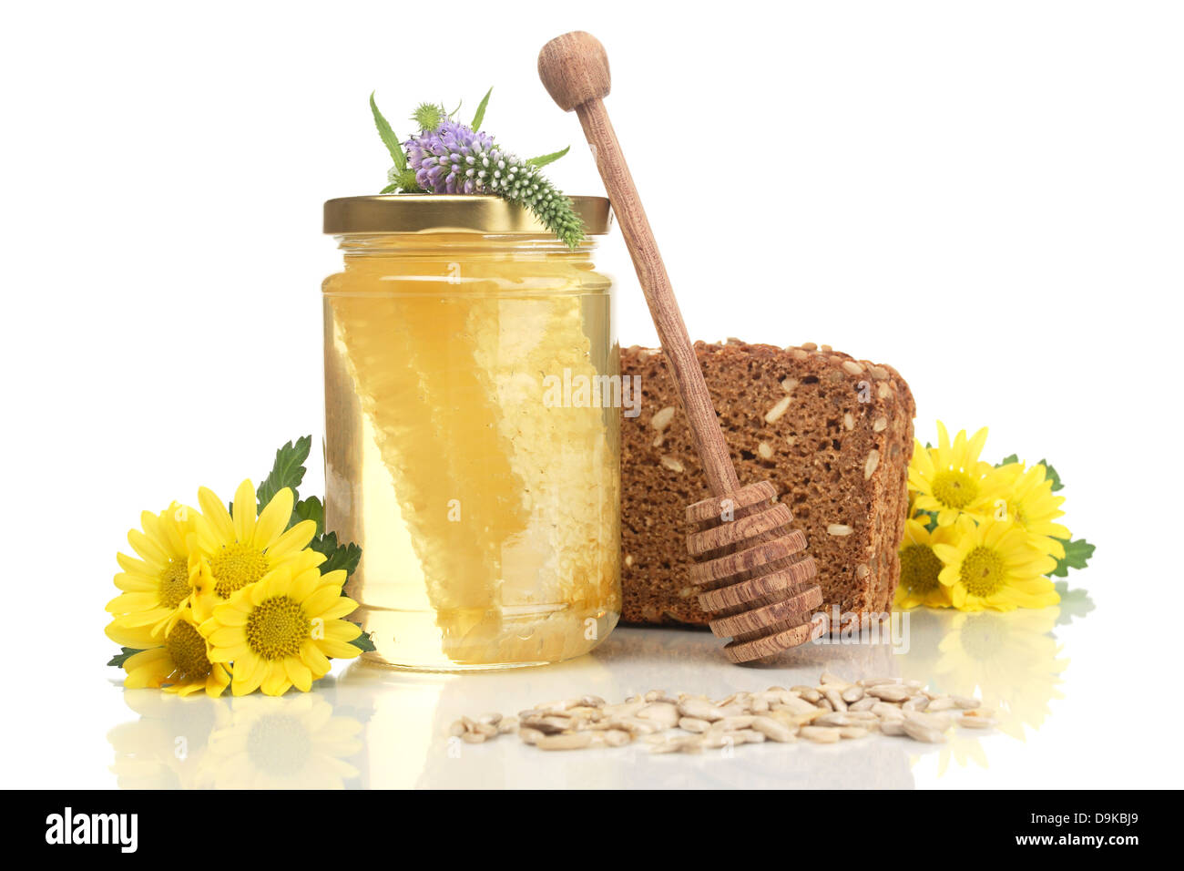 Kämmen Sie Honig mit Honig-Löffel, Sonnenblumen-Kerne und Blumen, Vollkornbrot, Vollkornbrot Brot mit Honig Kamm, Honig-Löffel, sunflow Stockfoto