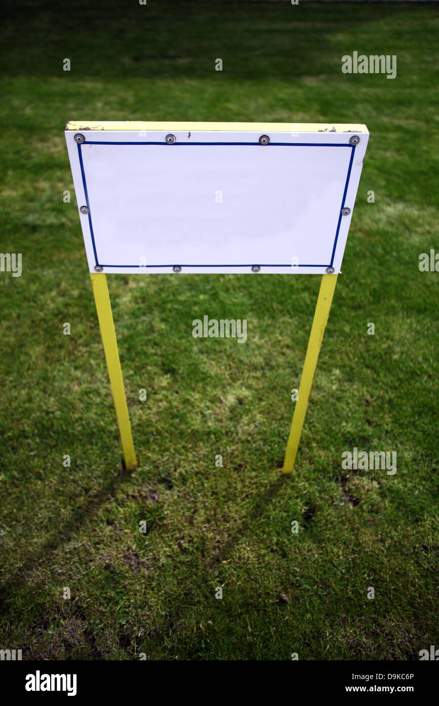 Eine leere weiße Plakatwand auf einem grünen Rasen-Hintergrund Stockfoto