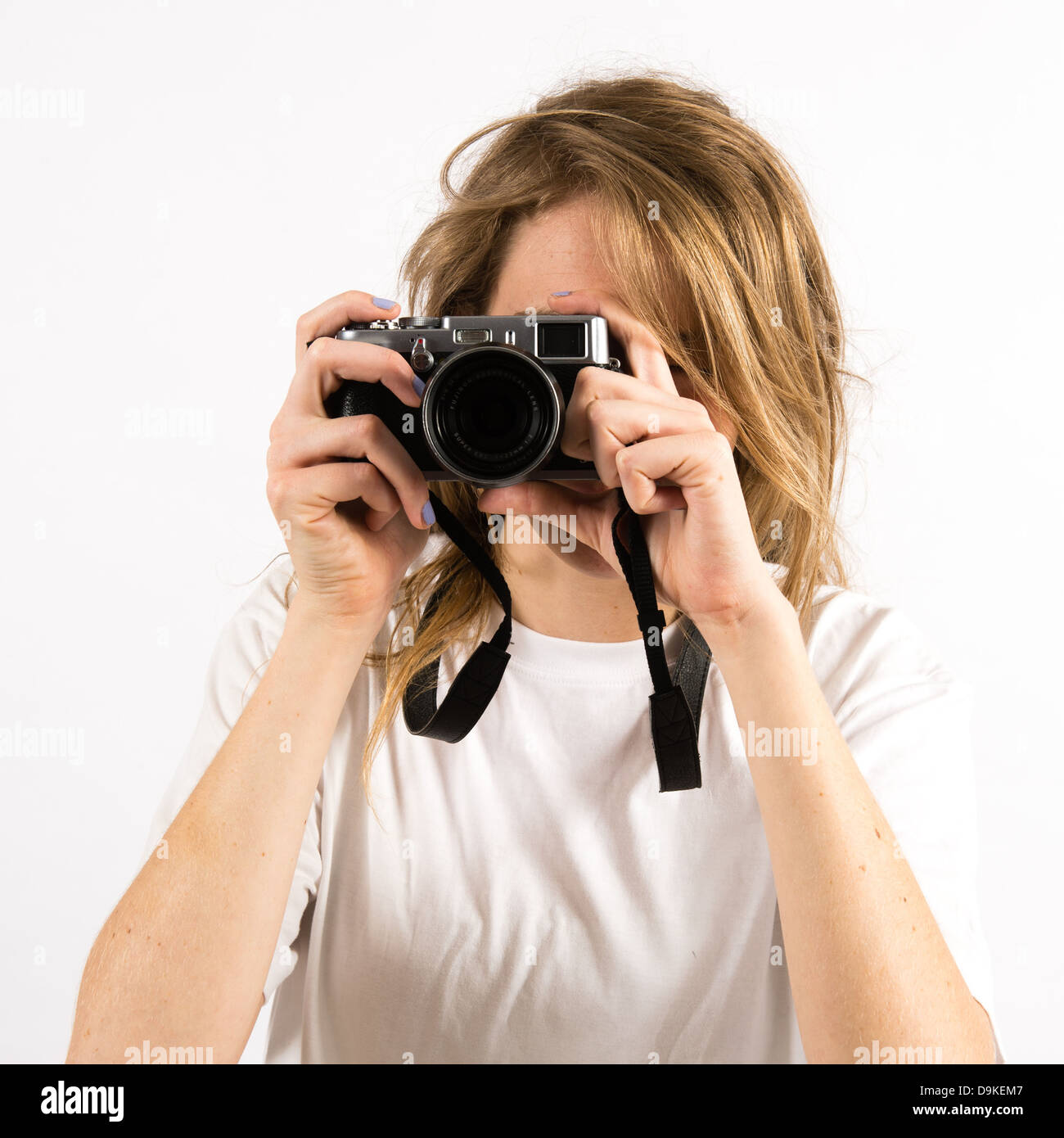 Junge Frau mit langen blonden Haaren, mit einer kleinen Digitalkamera Fuji X100s Fotograf Stockfoto