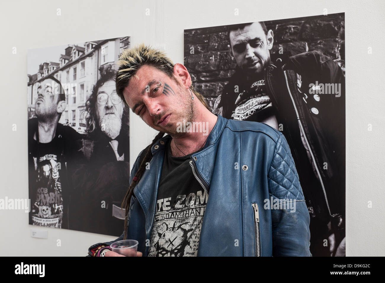 Ein Punk-Stil Mann stehend aus Fotos von sich selbst bei Studienabschluss-Ausstellung an der Aberystwyth University School of Art, UK Stockfoto