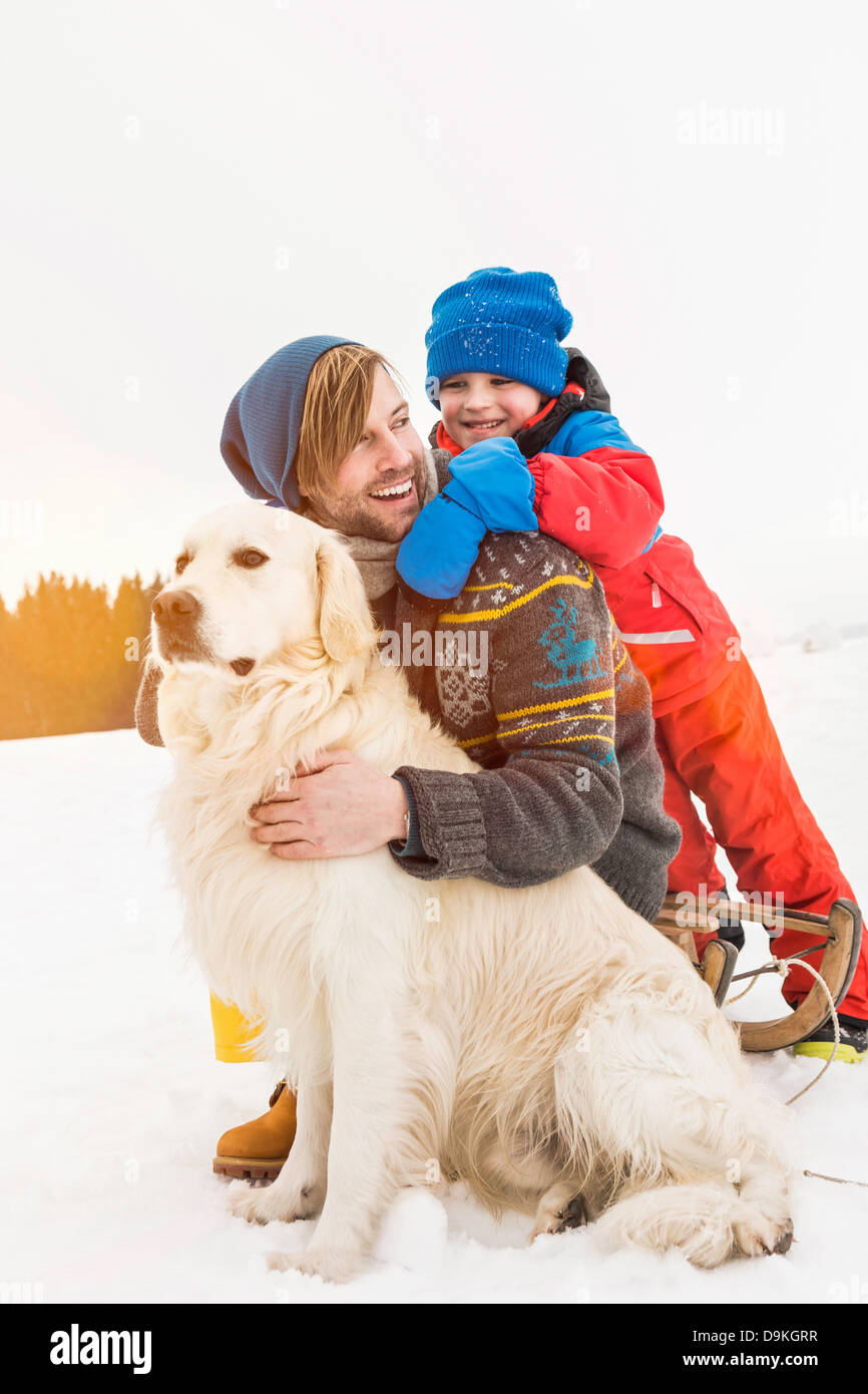 Vater und Sohn mit Hund im Schnee Stockfoto