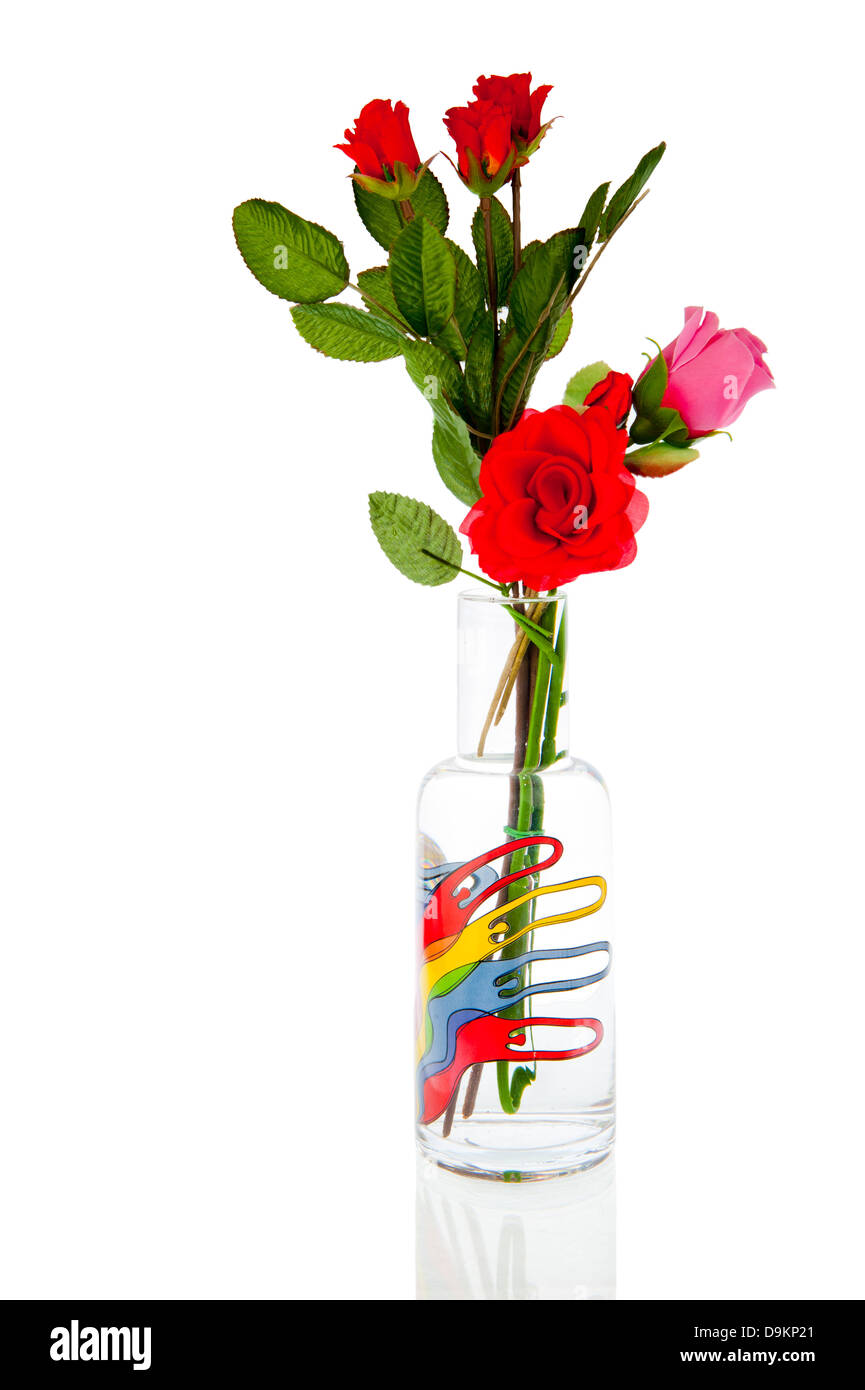 Glasvase mit Fingerpuppen gefüllt mit künstlichen Rosen rot und rosa Stockfoto