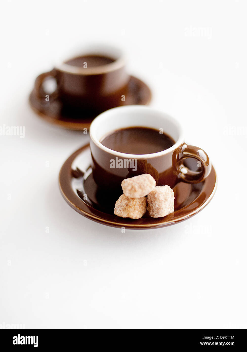 Frischer Kaffee in Tassen mit braunem Zucker Klumpen Stockfoto