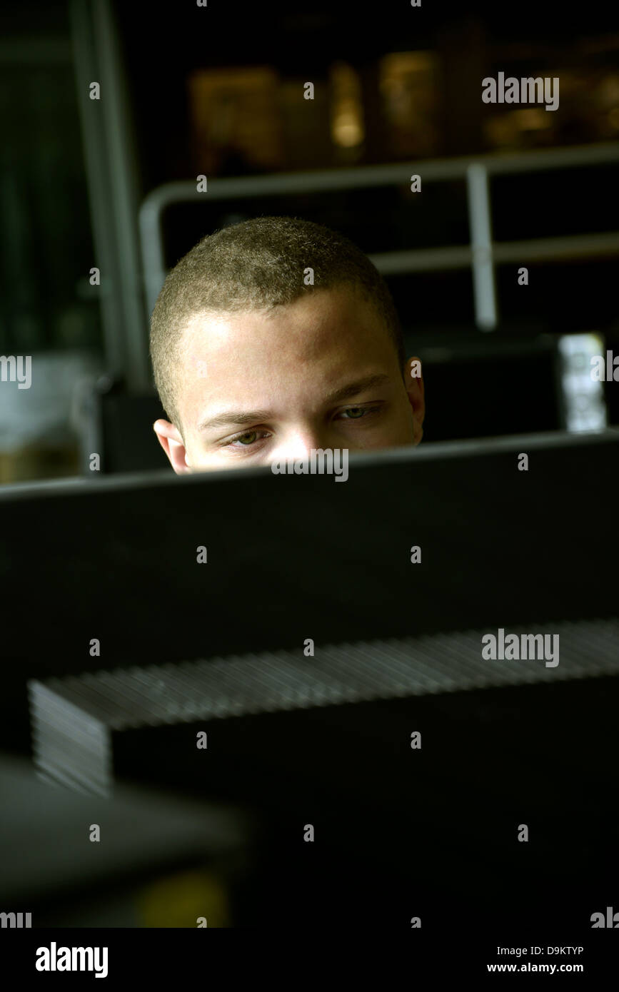 Ein junger Mann arbeitet auf einem Computer in einem Uni-Campus. Stockfoto