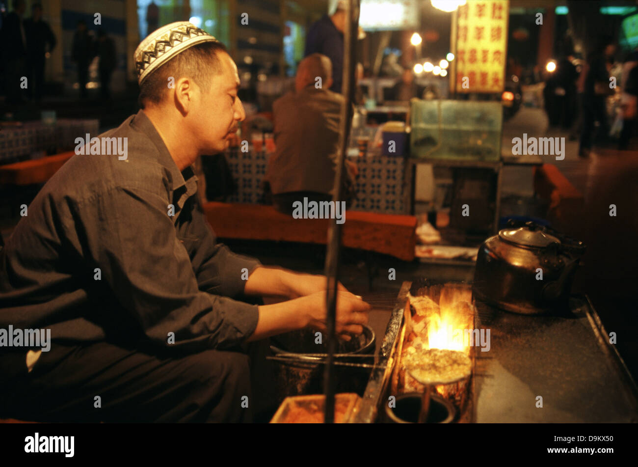 Eine muslimische Hui Mann grillen Fleisch bei shazhou Nachtmarkt Nachtmarkt oder Dunhuang in der Provinz Gansu in China Stockfoto Eine muslimische Hui Mann grillen Fleisch bei shazhou Nachtmarkt Nachtmarkt oder Dunhuang in der Provinz Gansu in China Stockfoto