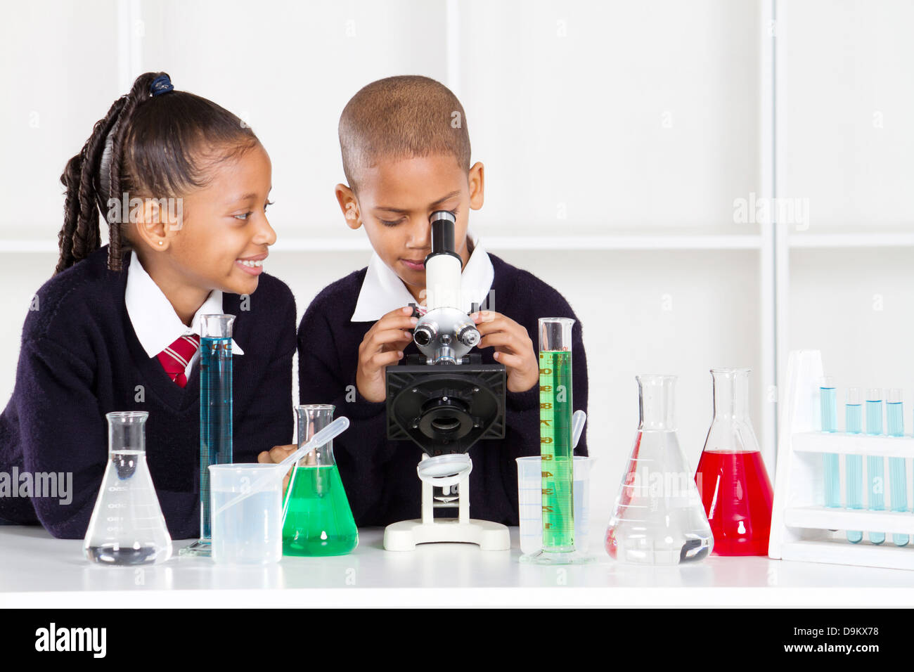 Grundschule Kinder im naturwissenschaftlichen Unterricht mit einem Mikroskop Stockfoto