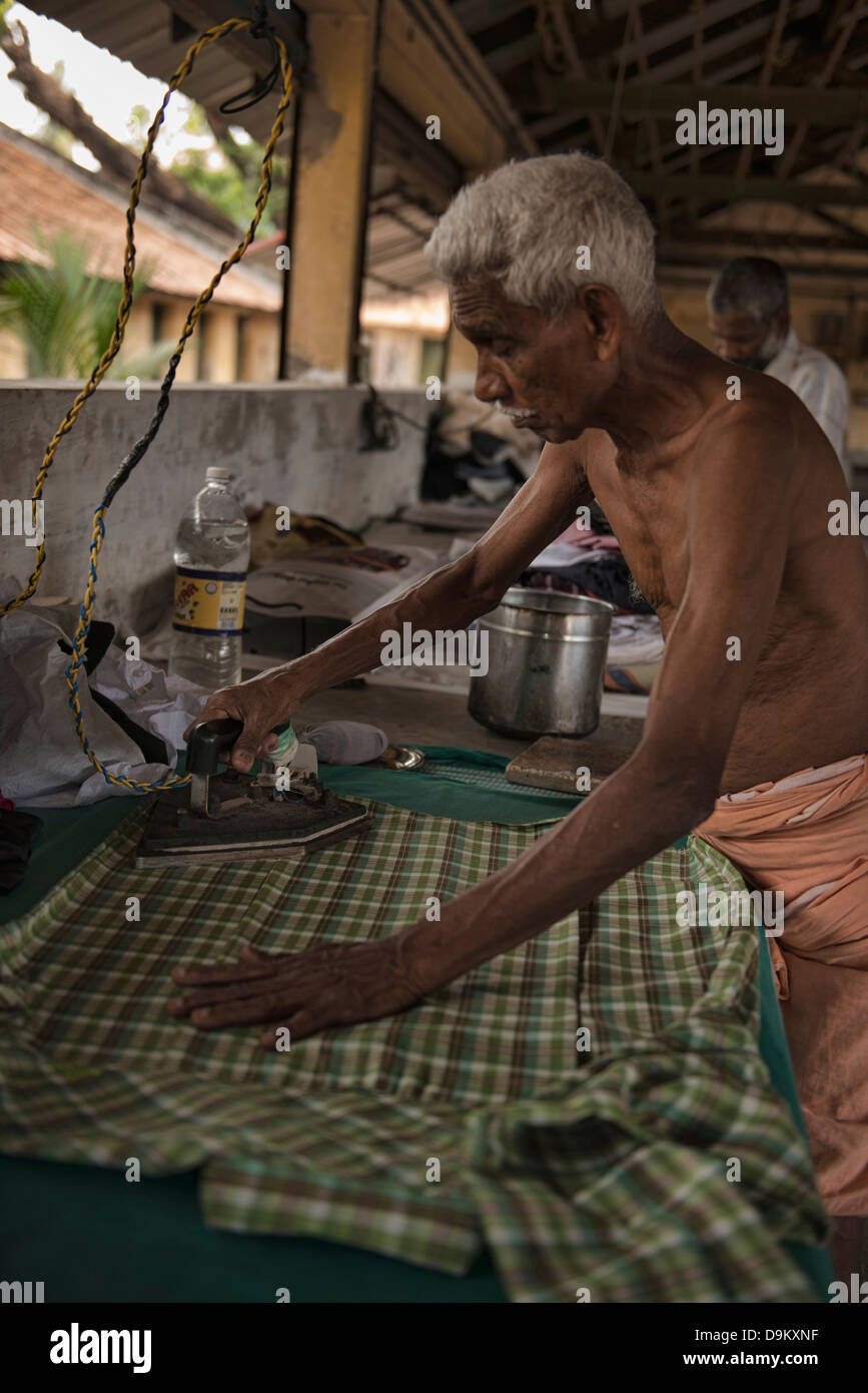traditionelle Bügeln der Kleidung in der Öffentlichkeit Wäscherei in Fort Cochin (Kochi), Kerala, Indien Stockfoto