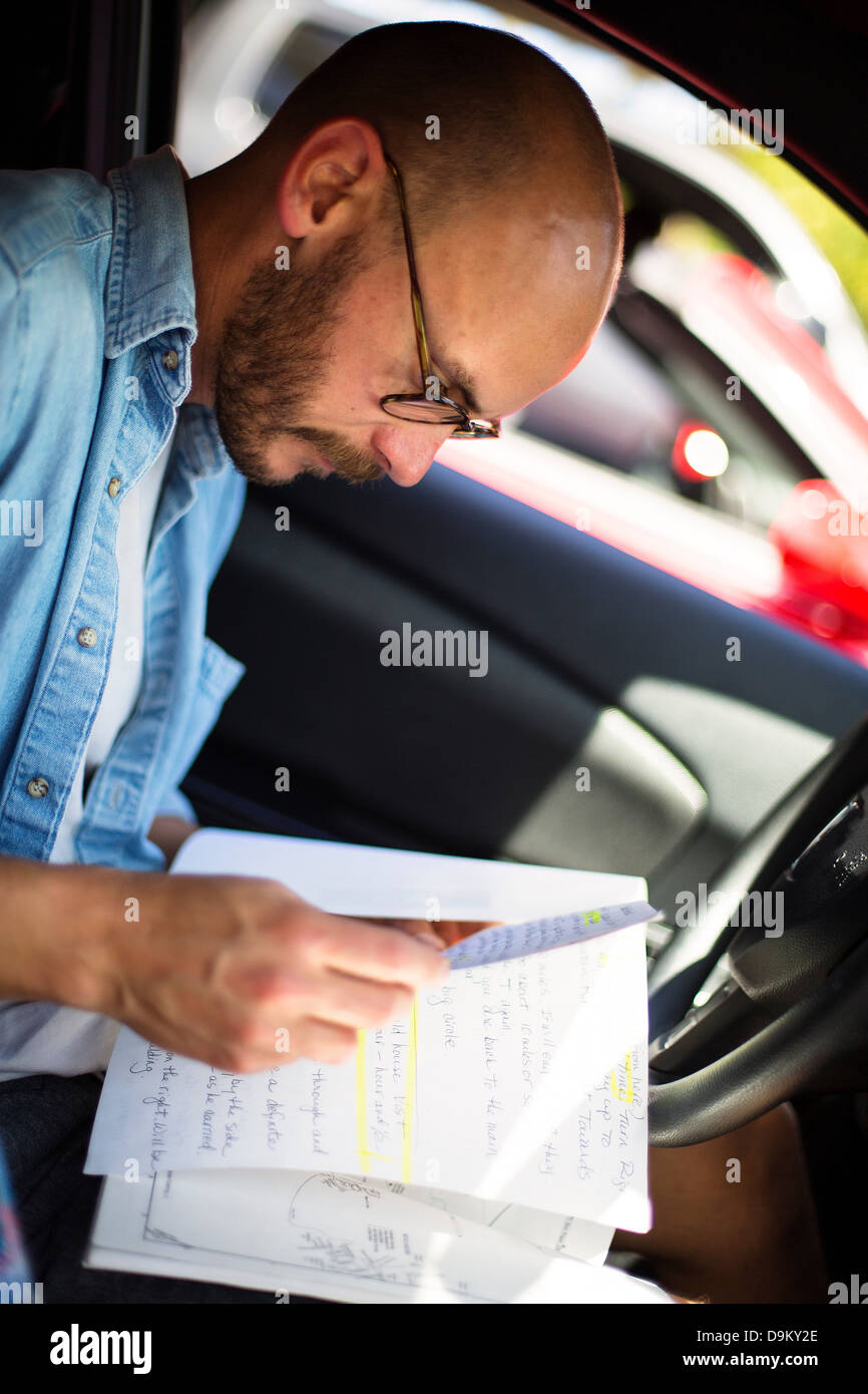 Mitte erwachsenen Mannes Notenlesen in Auto Stockfoto