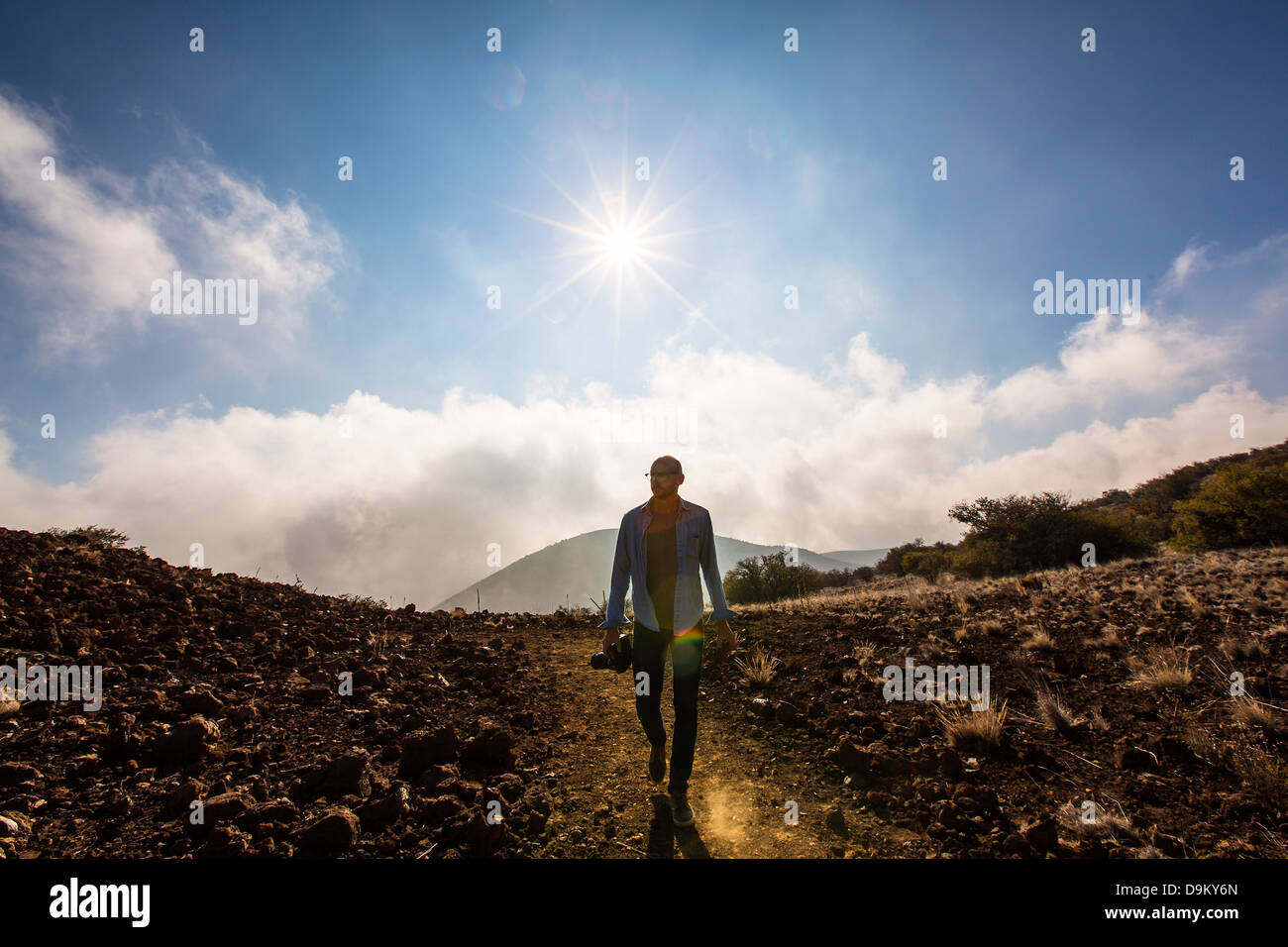 Mitte erwachsener Mann mit Kamera in sonnige Landschaft Stockfoto