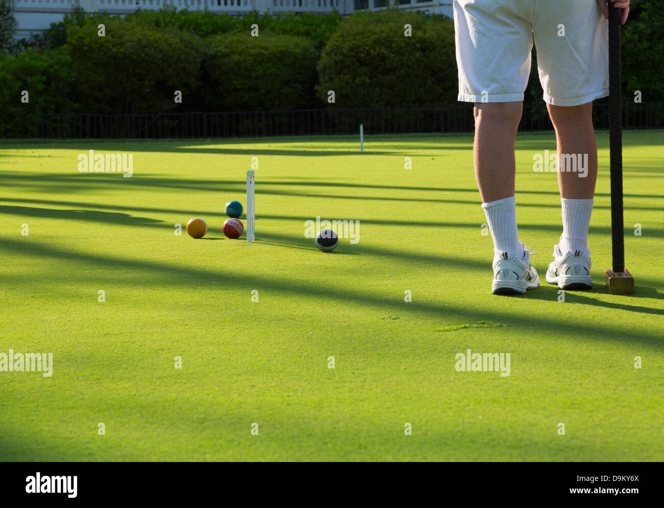 Eine Partie Golf Croquet. Ein Spieler beobachtet, wie ein anderer Spieler Ball nähert sich das Wicket. Stockfoto