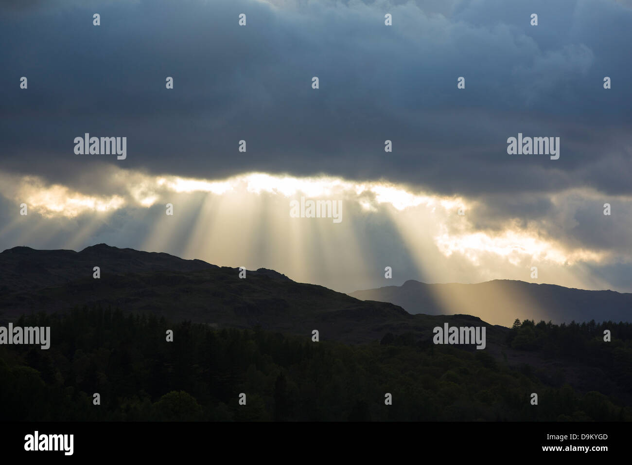 Sonnenlicht durchströmen Hle in den Wolken bei Sonnenuntergang über dem Loughrigg in Lake District, Cumbria, England. Stockfoto