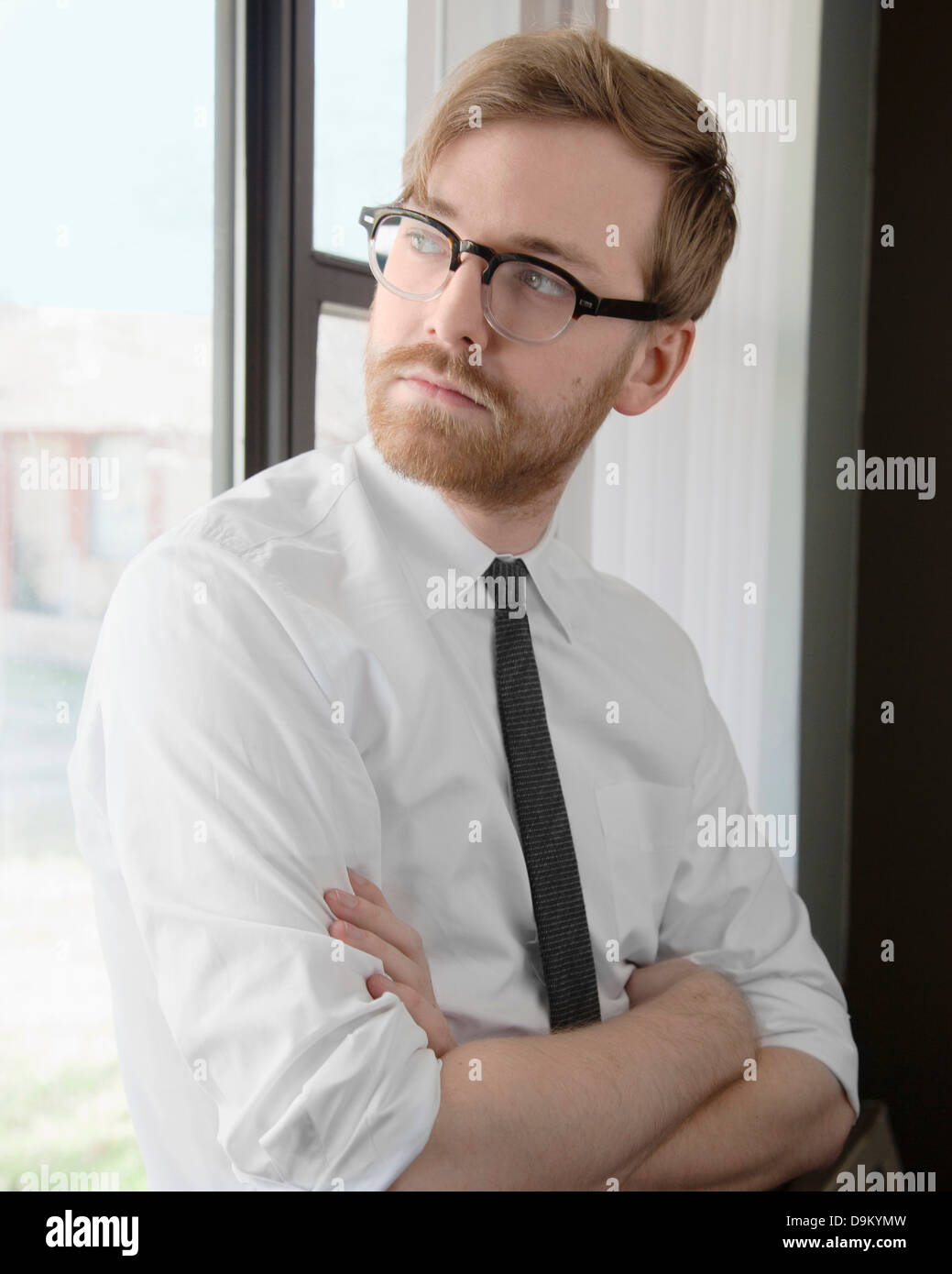 Junger Mann mit Brille und Krawatte wegschauen Stockfoto