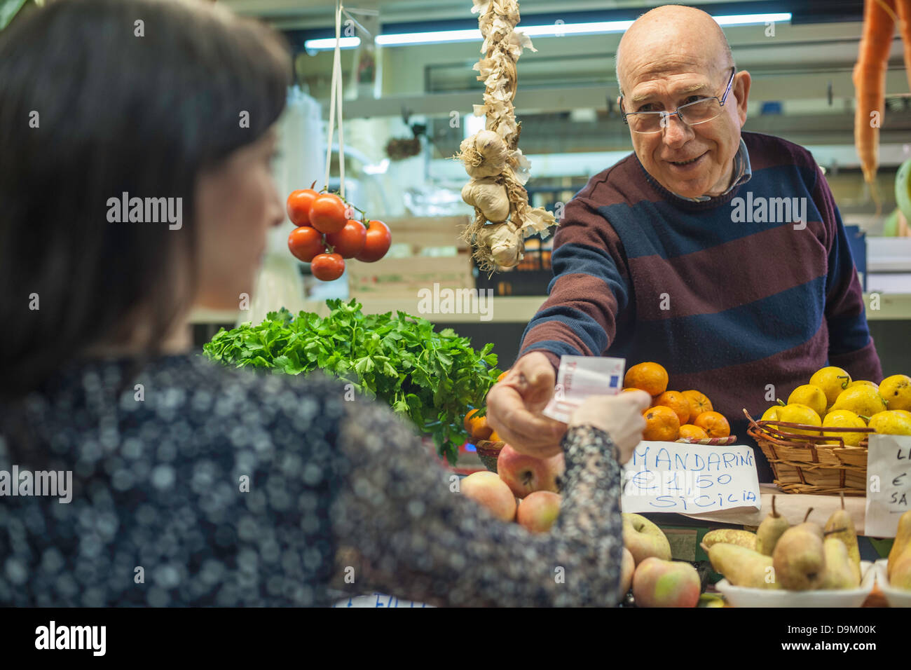 Ladenbesitzer Übergabe Veränderungen an Kundin im Markt Stockfoto