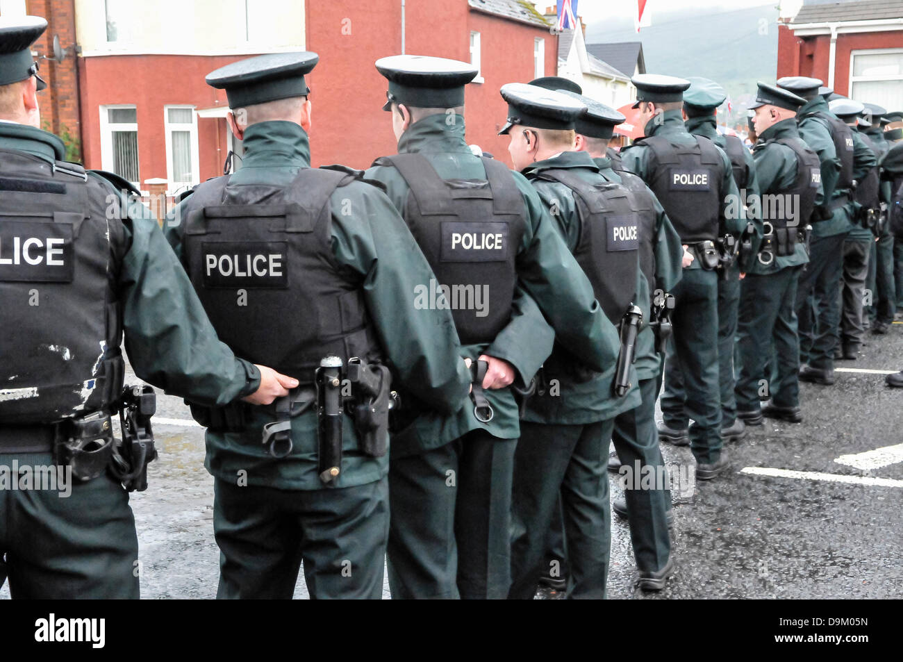 Uniformierte Polizei Polizisten Warnschutz Jacke tragen bilden eine Linie über eine Straße, eine Menge von Verfahren zu stoppen Stockfoto