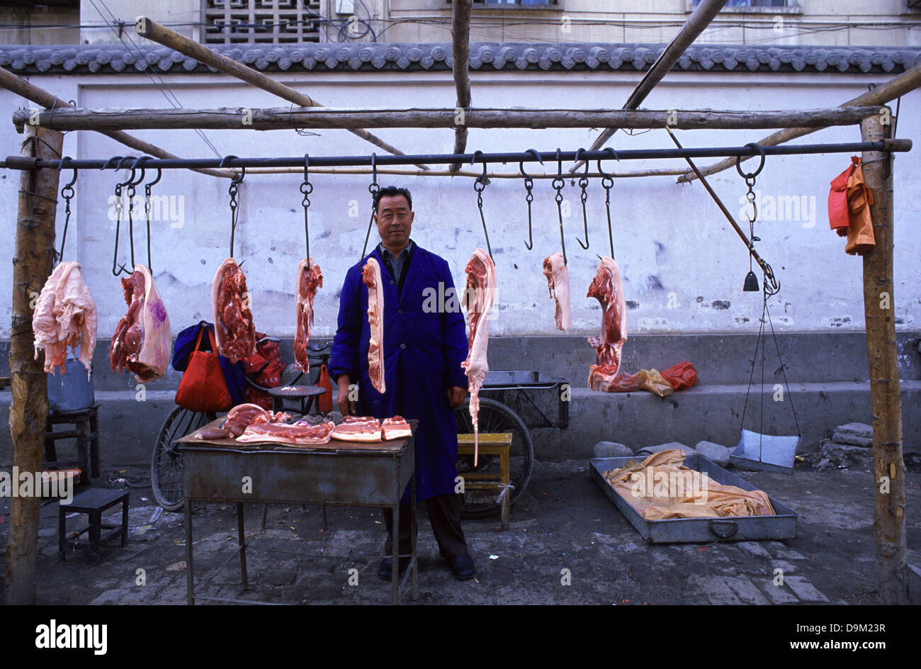 Ein Anbieter Verkauf von rohem Fleisch auf dem Markt von Zhangye, oder als Kanchow, eine Stadt in der Provinz Gansu in China bekannt Stockfoto Ein Anbieter Verkauf von rohem Fleisch auf dem Markt von Zhangye, oder als Kanchow, eine Stadt in der Provinz Gansu in China bekannt Stockfoto