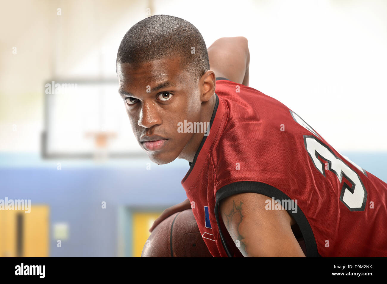 Young African American Basketball-Spieler spielen im Innenbereich Stockfoto