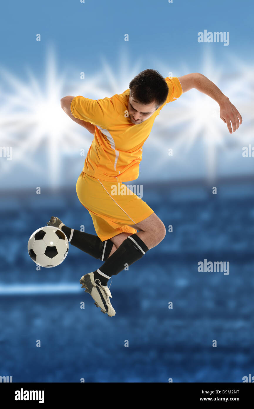 Fußball-Spieler durchführen Back Kick im Stadion in der Abenddämmerung Stockfoto
