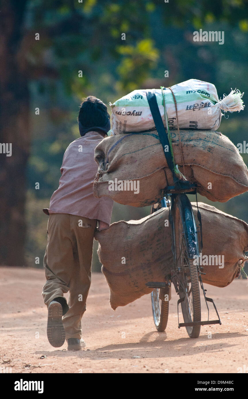 Indianerjunge starker Druckbelastung auf dem Fahrrad in Nord-Zentral-Indien Stockfoto