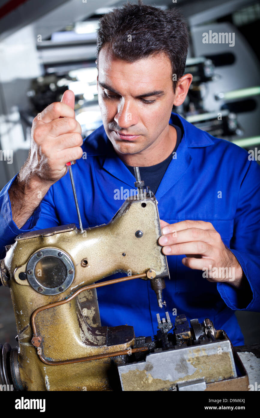 Mechaniker reparieren Industrienähmaschine in Fabrik Stockfoto