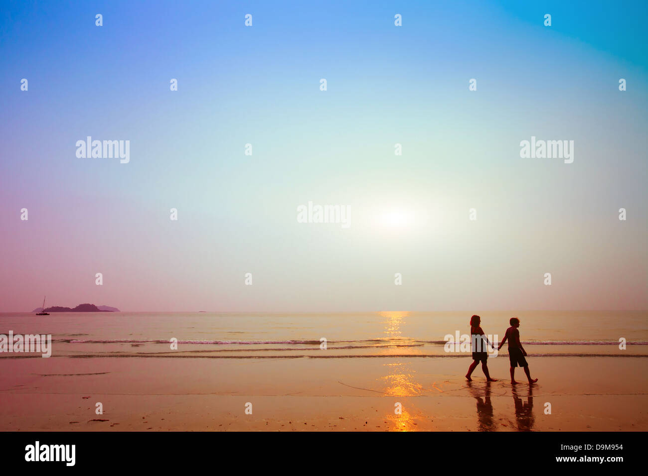 Silhouetten von paar am Strand bei Sonnenuntergang Stockfoto