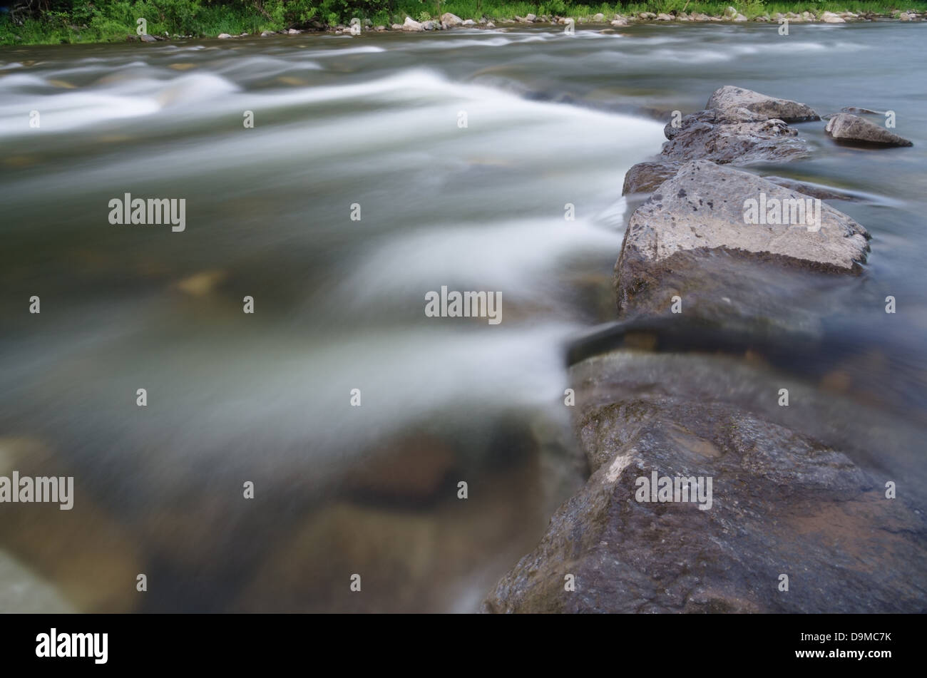 Langzeitbelichtung ein Fluss fließt über die Felsen mit seidig fließend Wasser Stockfoto