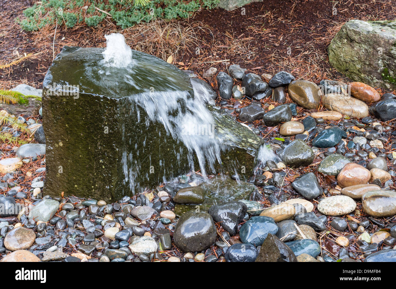 Eine felsige sprudelnden Wasser-Brunnen in einem Garten im Innenhof Stockfoto