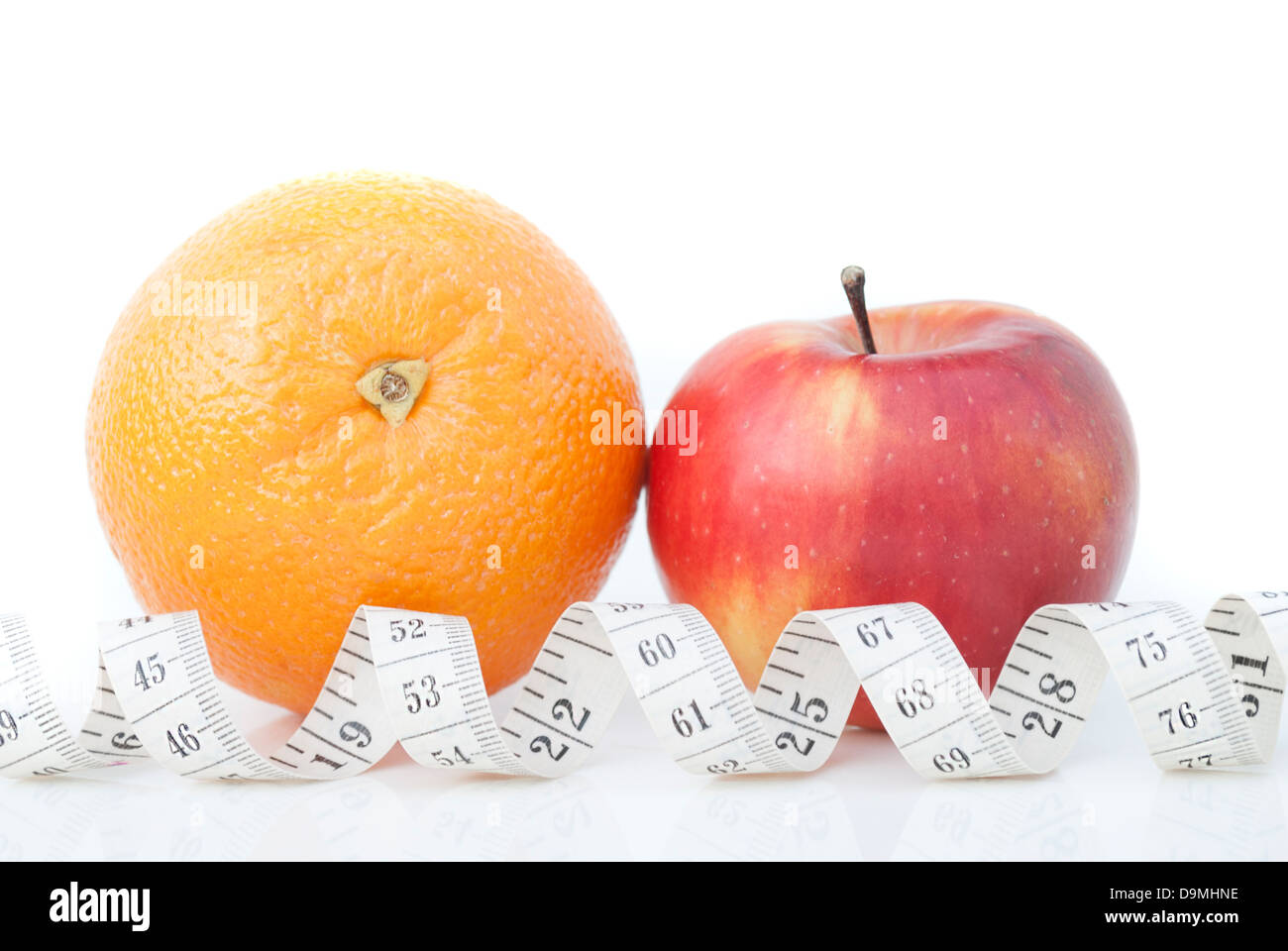 Orange und Apfel mit einem Maßband auf weißem Hintergrund. Stockfoto