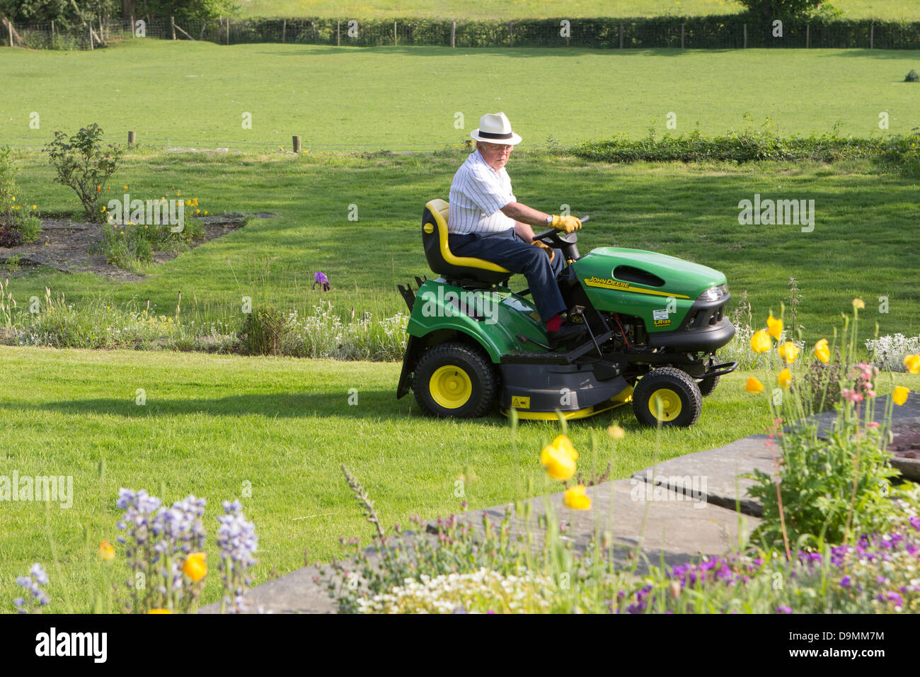 Mann auf einem Sit-on-Mäher Stockfoto