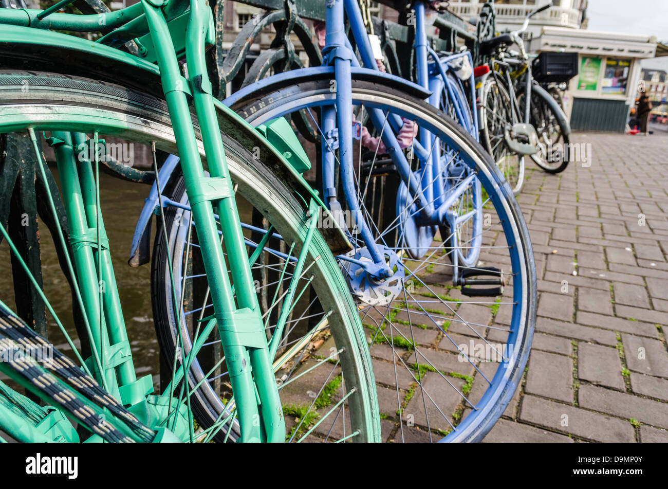 Grün und lila Fahrräder eine Amsterdam-Kanal entlang. Amsterdam, NL. Stockfoto