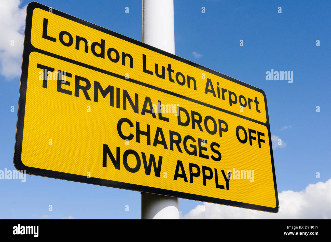 Schild am Eingang zum Flughafen Luton, dass Achtung Autofahrer das terminal drop-off Kosten jetzt bewerben Stockfoto