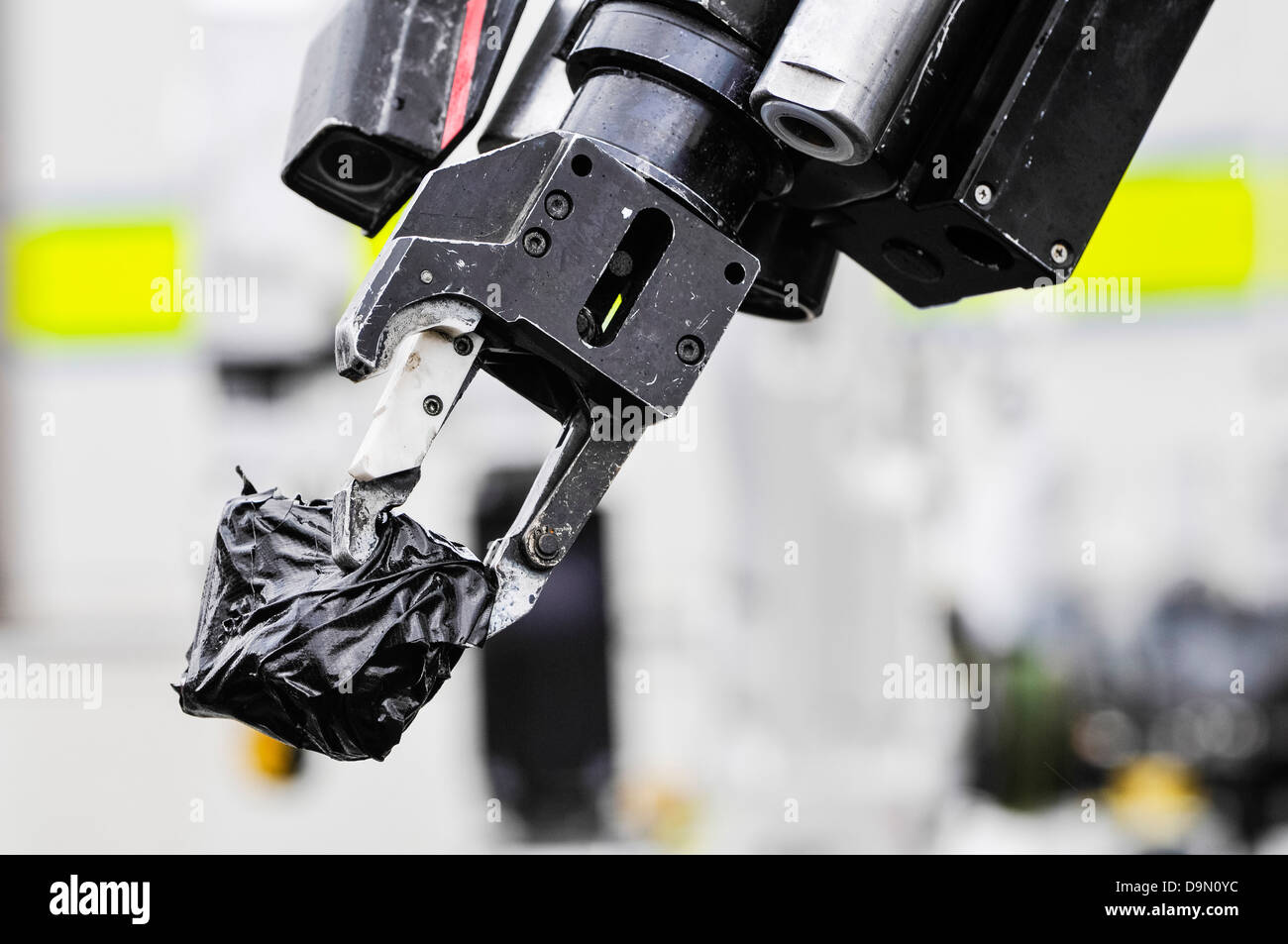 Zange Griff von einem Roboter Armee Bombe zur hält einen verdächtigen Gegenstand in Klebeband eingewickelt Stockfoto