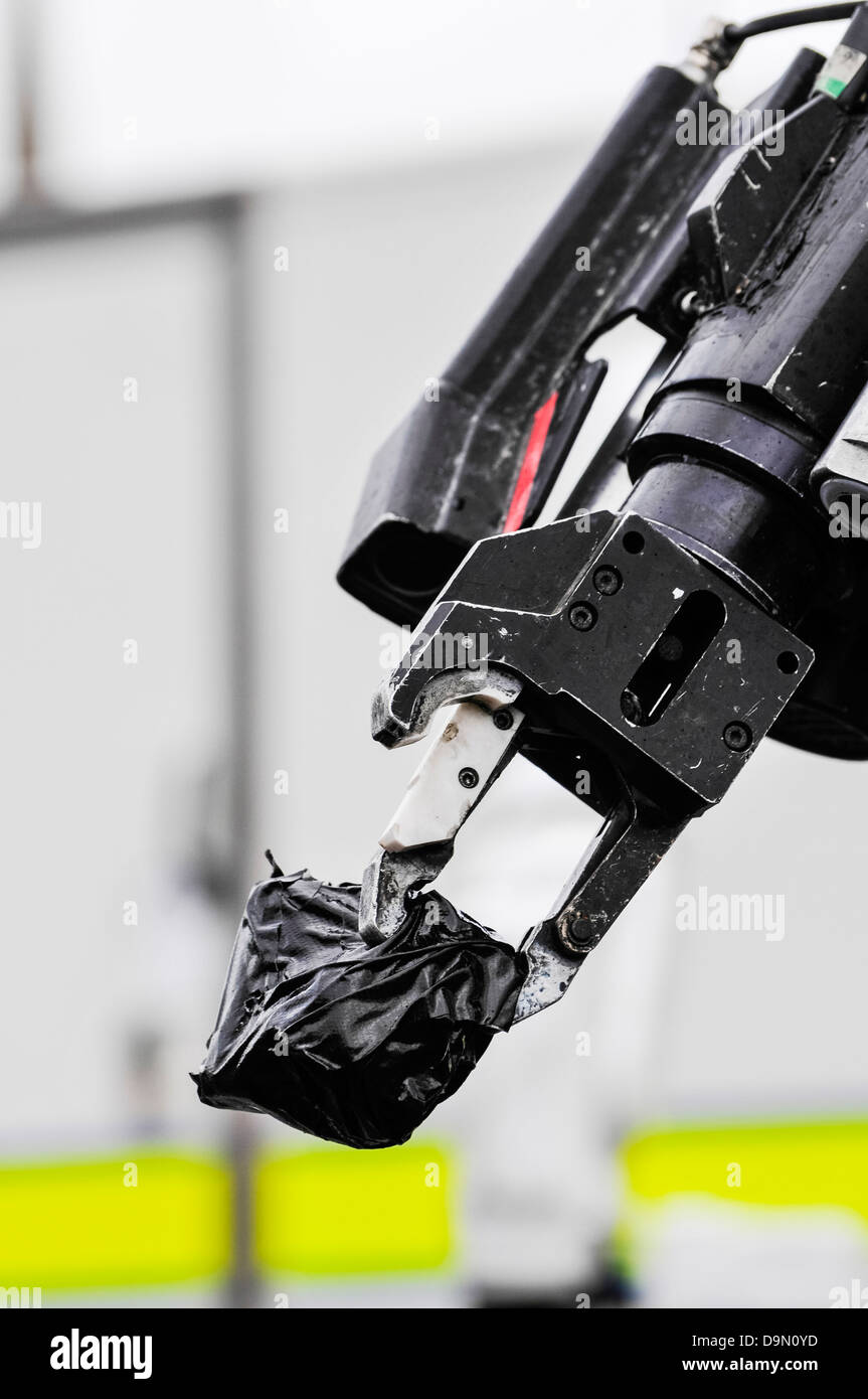 Zange Griff von einer Armee Roboter "Schubkarre" Bombe zur hält einen verdächtigen Gegenstand in Klebeband eingewickelt Stockfoto