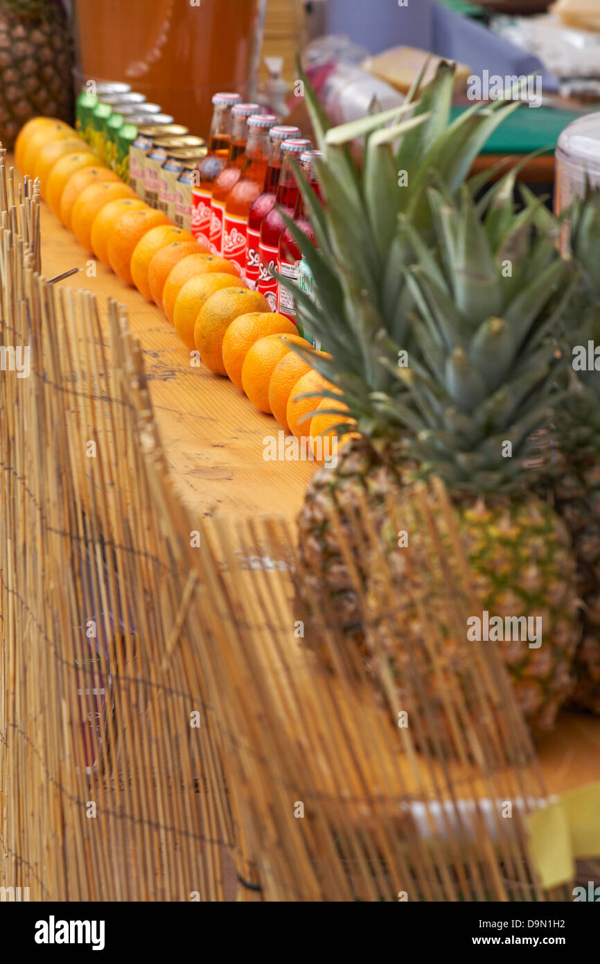 Ananas, Orangen und Flaschen und Dosen des Getränks auf dem Display für Bournemouth Food & Drink Festival - karibischen Stil Stockfoto