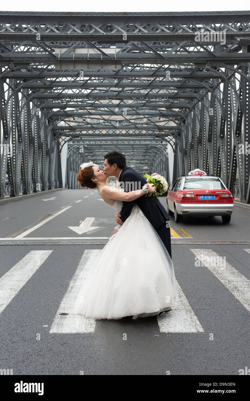 Ein junges Ehepaar posieren für Hochzeitsfotos auf der Waidaibu-Brücke in Shanghai Stockfoto