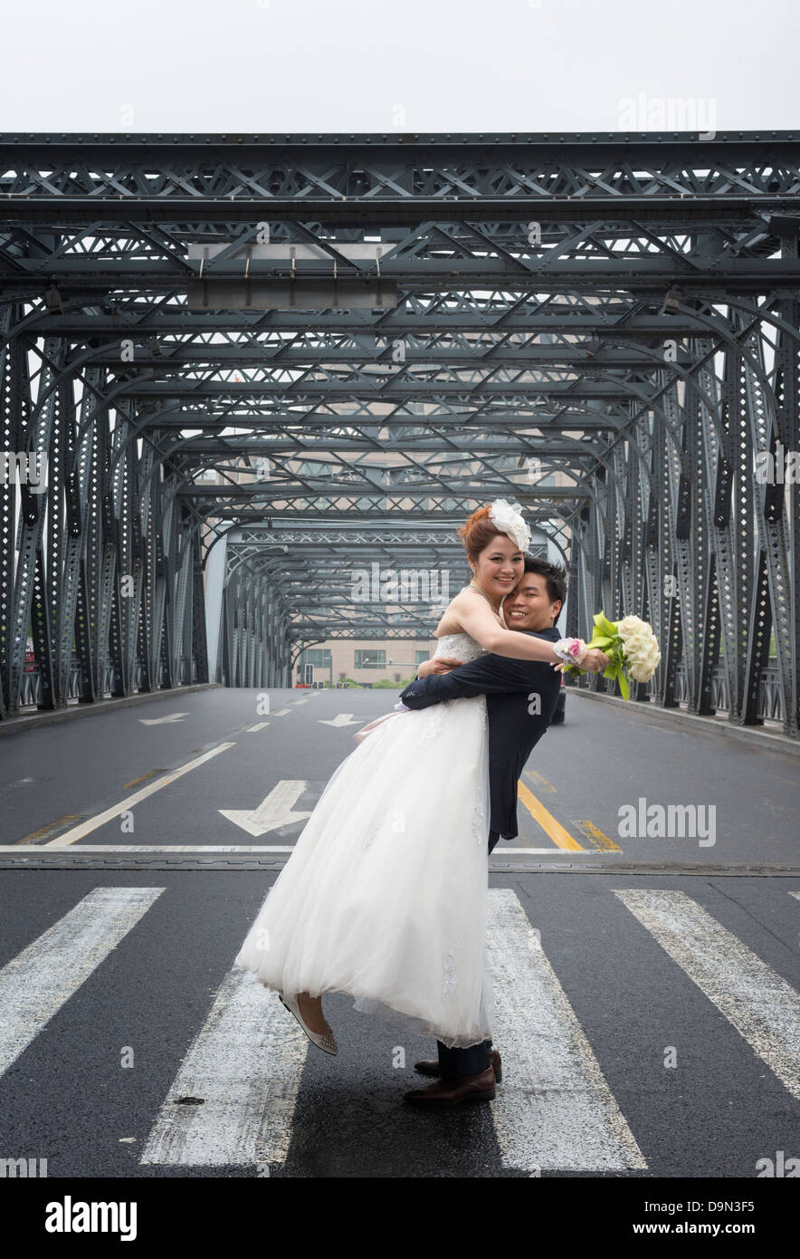 Ein junges Ehepaar posieren für Hochzeitsfotos auf der Waidaibu-Brücke in Shanghai Stockfoto