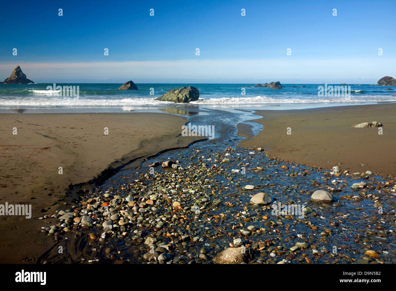 OREGON - kleiner Bach überqueren den Sand am Strand von Lone-Ranch am Rande des Pazifischen Ozeans in Samuel H. Boardman State Park. Stockfoto