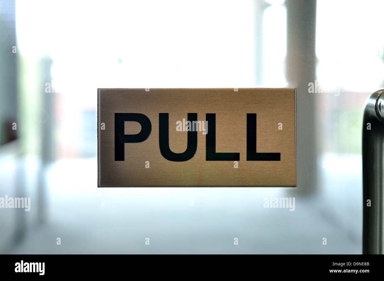 Bild eines Pull-Zeichens auf eine Glastür in einem n Bürogebäude. Hintergrund ist unscharf. Stockfoto