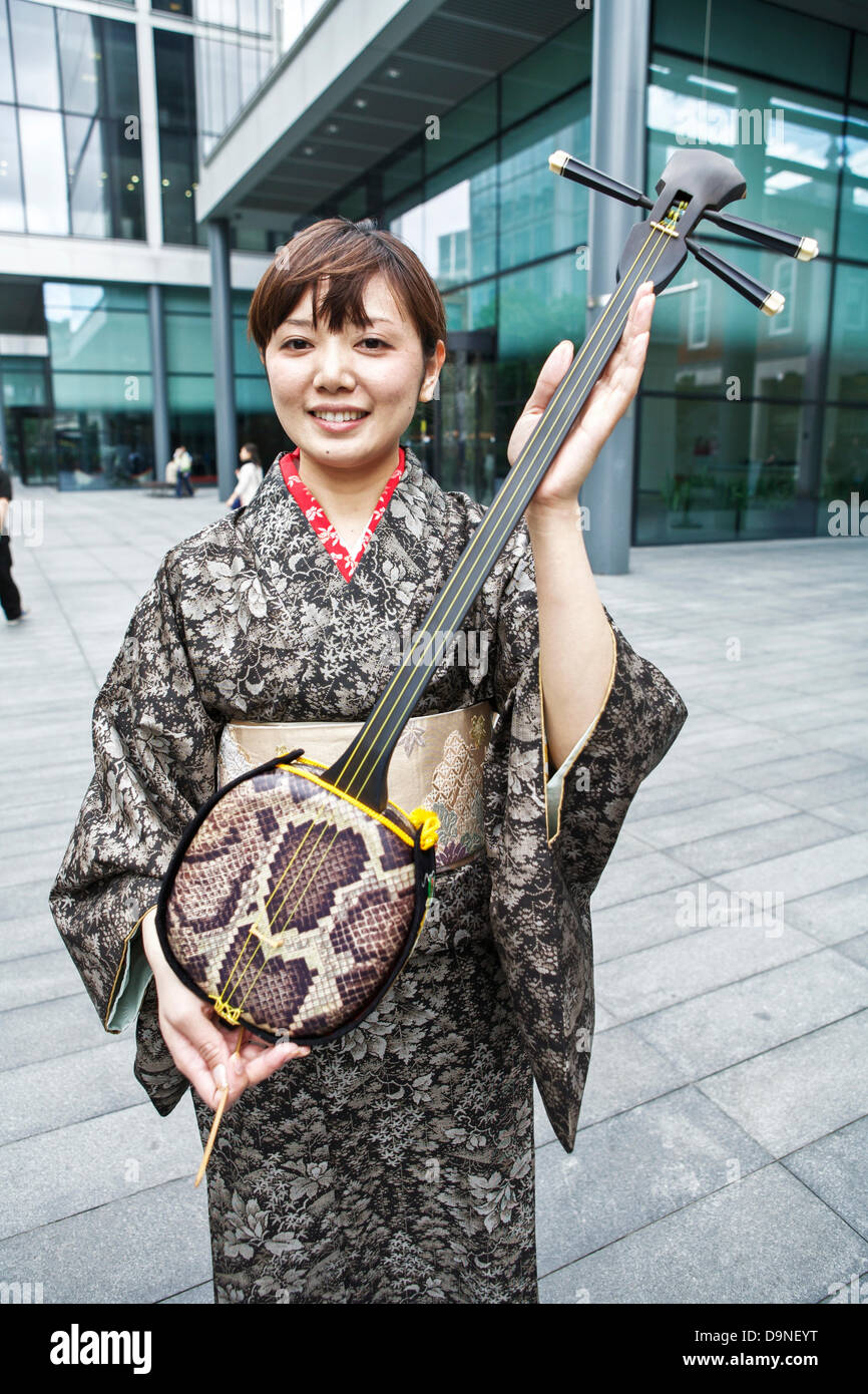 Sanshin ein drei stringed traditionelles Musikinstrument aus Okinawa angezeigt wird von einem japanischen Frauen tragen einen kimono Stockfoto