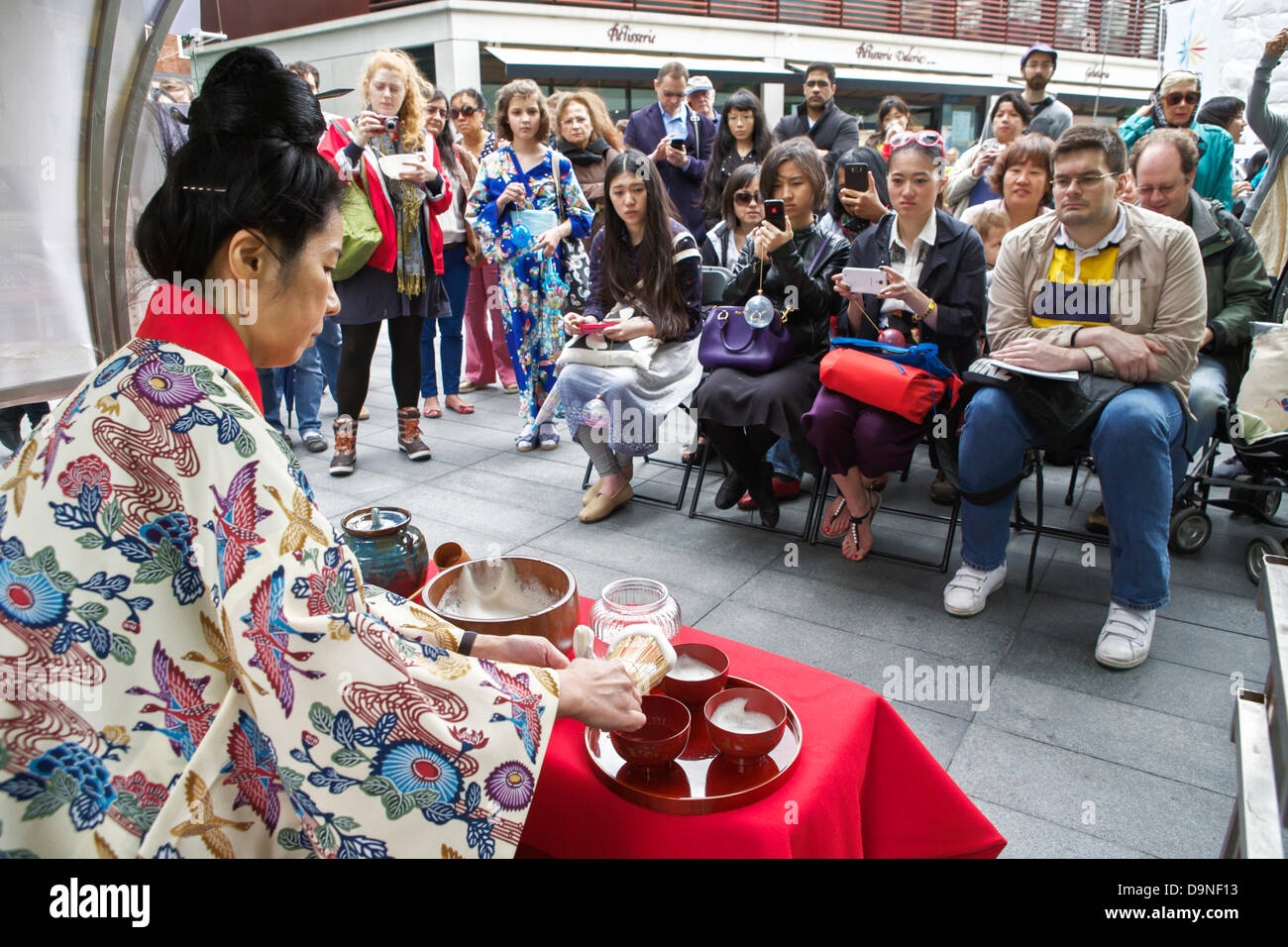 Okinawa-Tee-Zeremonie, bereitet eine Japanerin Tee traditioneller Weise mit einem Zuschauer Stockfoto