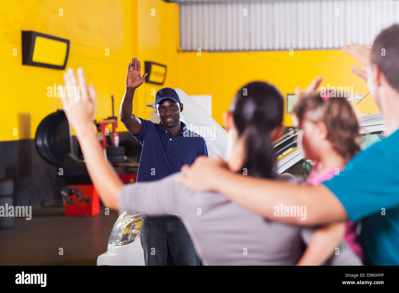 freundliche afrikanische Auto-Reparatur-Shop Arbeiter wehenden Abschied von Kunden Stockfoto