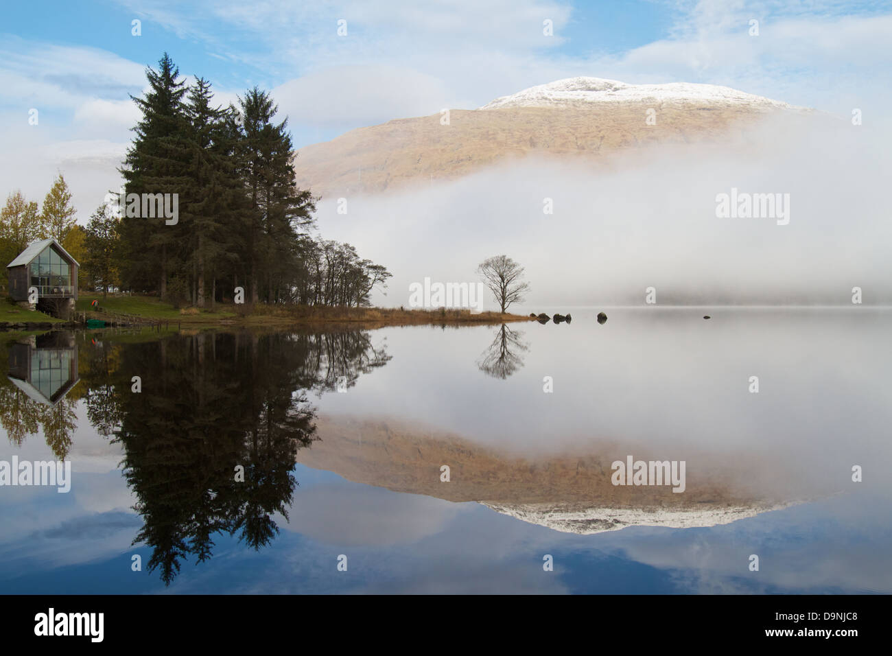 Eine schneebedeckte Ben Cruachan Berg durch Nebel über Loch Awe, aus dem Gelände des Ardanaiseig Hotel gesehen. Stockfoto